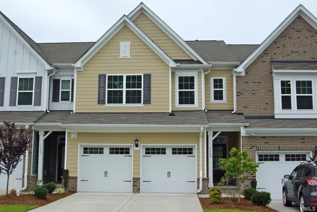 a view of a house with a yard and potted plants