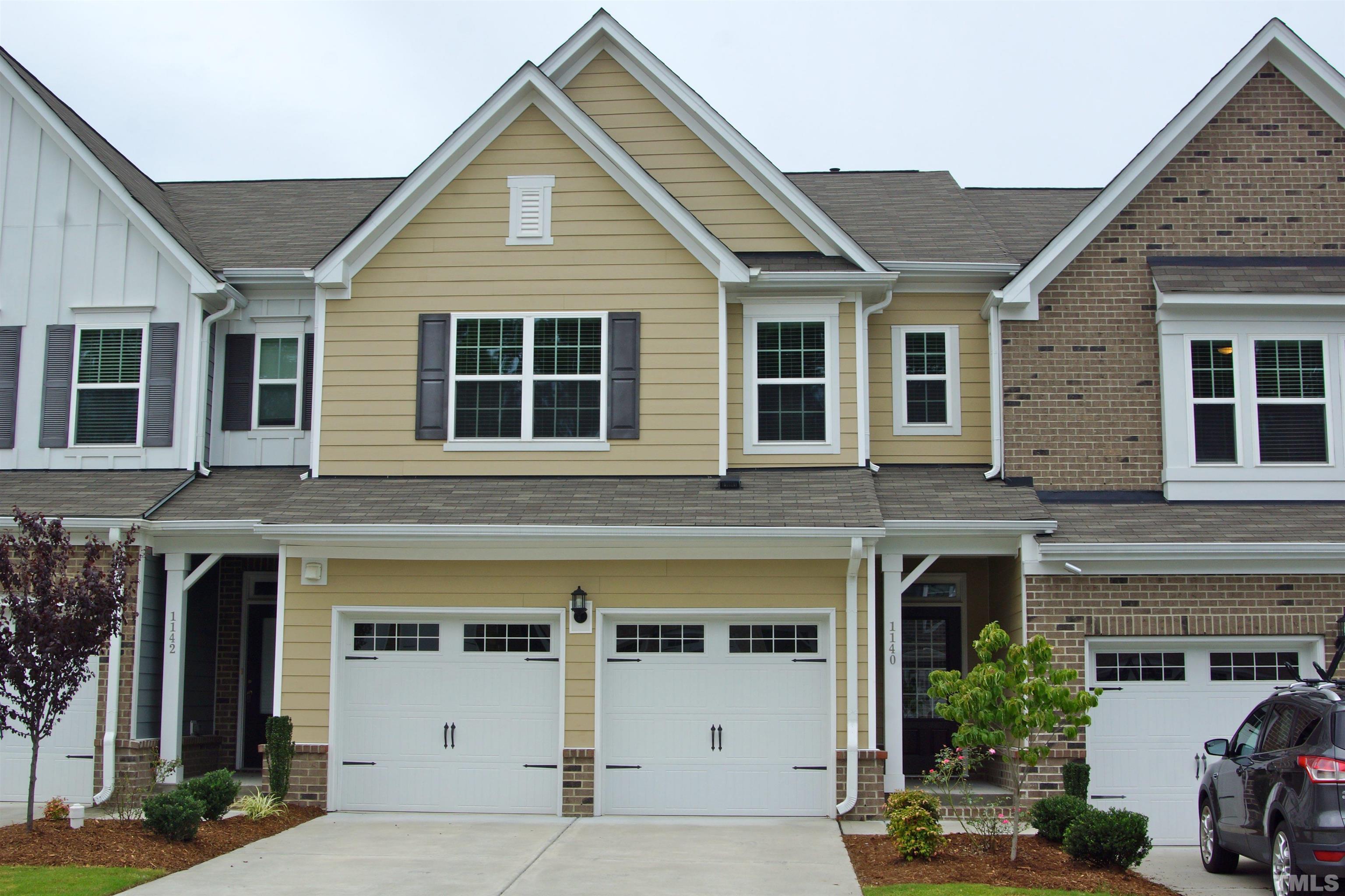 a view of a house with a yard and potted plants