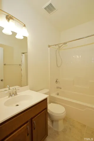 a bathroom with a granite countertop sink a toilet and shower