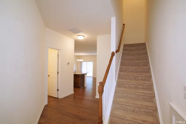 a view of a hallway with wooden floor and staircase