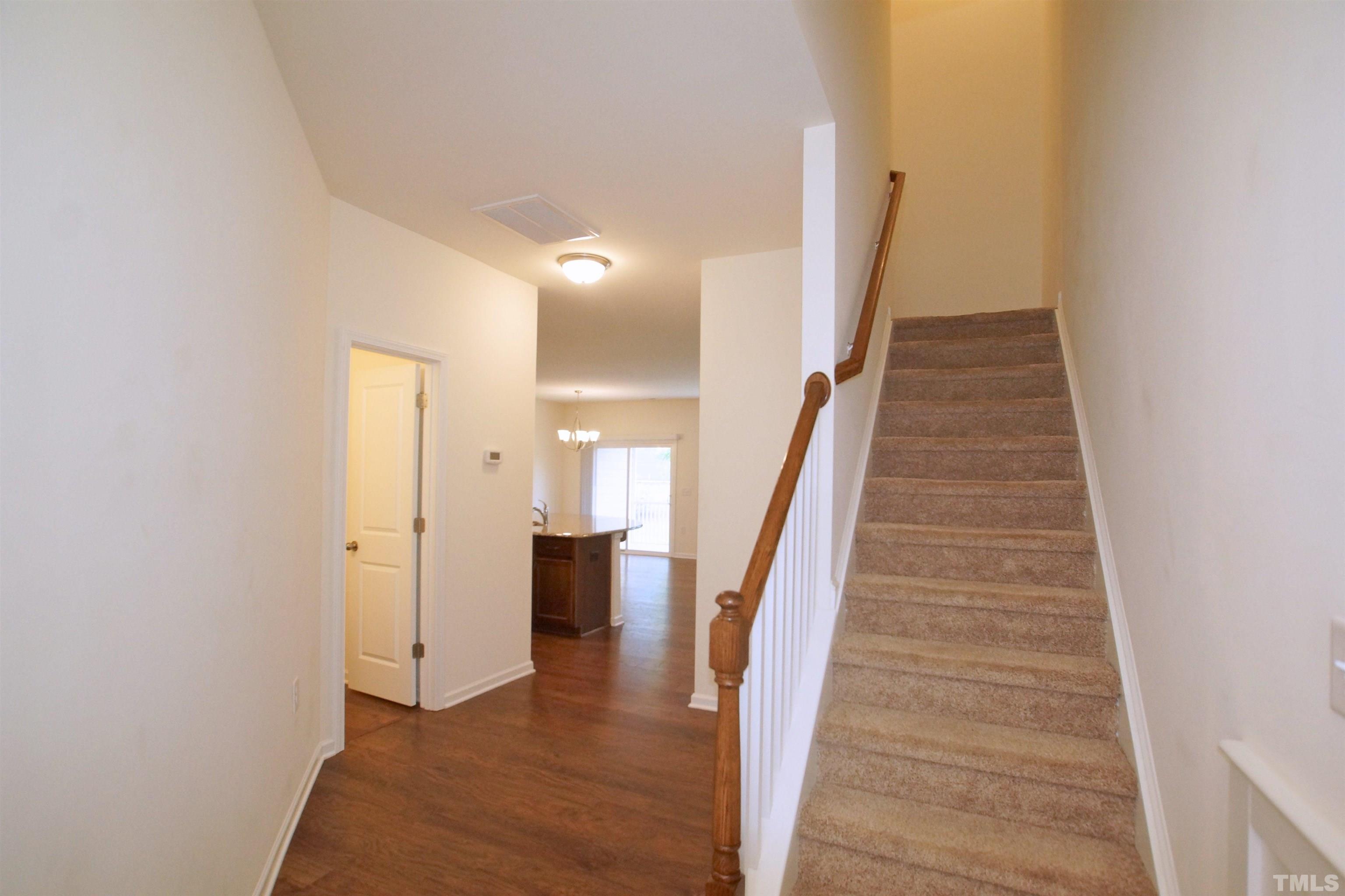 1140 Lookout Ridge Road Apex, NC 27502 - Photo 3 of 22 a view of a hallway with wooden floor and staircase
