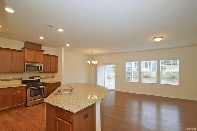 a kitchen with stainless steel appliances granite countertop a stove top oven a sink and a microwave