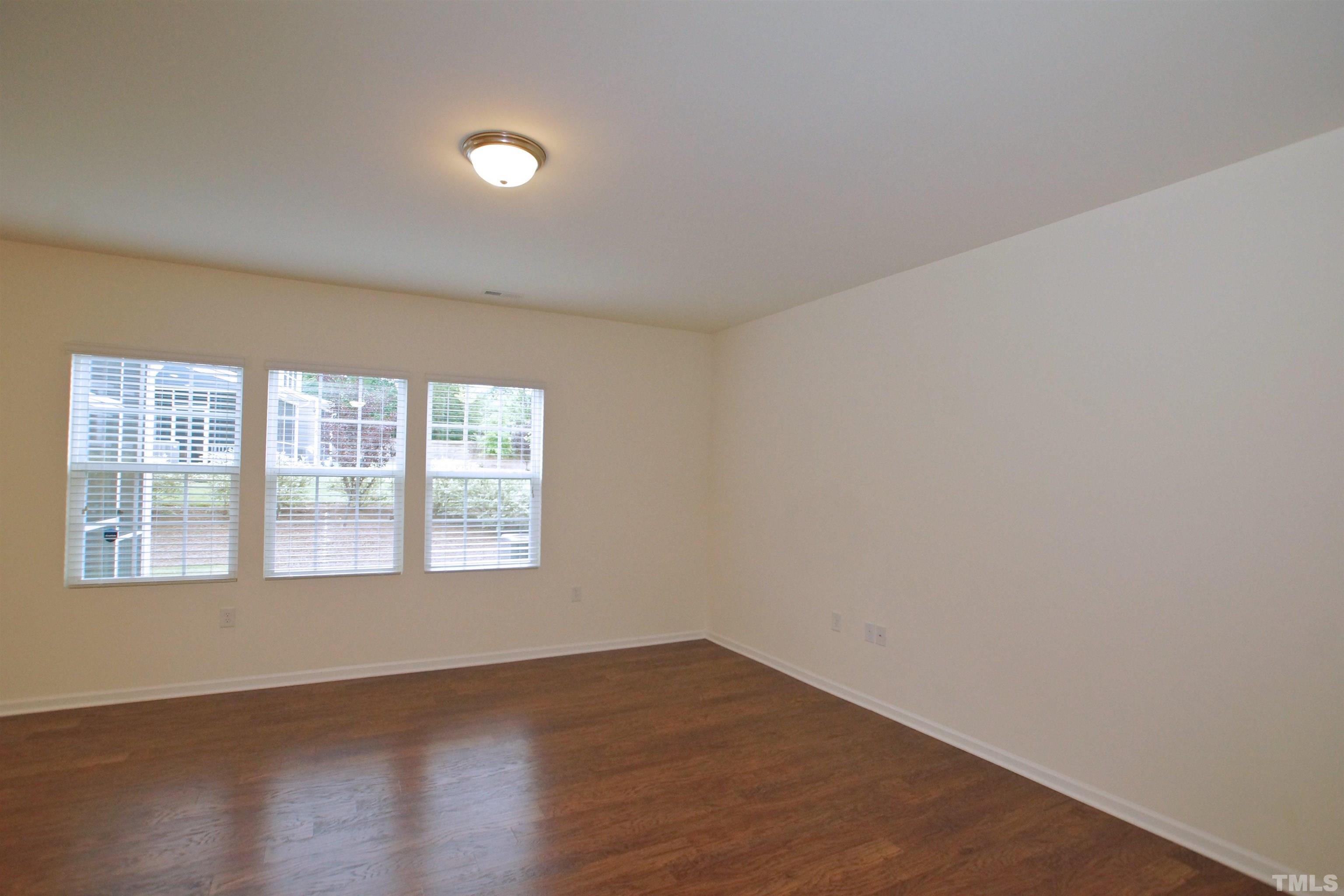 1140 Lookout Ridge Road Apex, NC 27502 - Photo 5 of 22 an empty room with wooden floor and windows