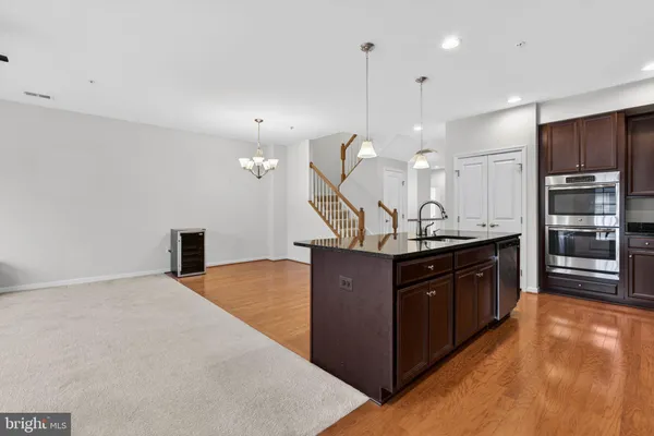 a kitchen with stainless steel appliances granite countertop a sink a stove and a refrigerator