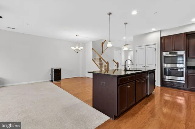 a kitchen with stainless steel appliances granite countertop a sink a stove and a refrigerator