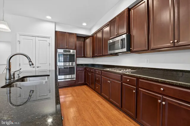 a kitchen with stainless steel appliances granite countertop a sink and cabinets