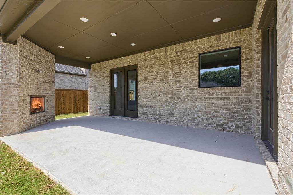 709 Anne Road Van Alstyne, TX 75495 - Photo 24 of 28 Covered patio featuring an outdoor fireplace, recessed lighting, brick exterior, and concrete flooring