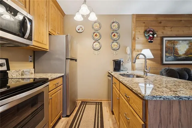 a kitchen with a sink and a stove with wooden floor