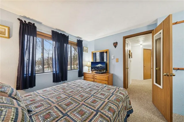 a bedroom with a bed and a dresser next to a window