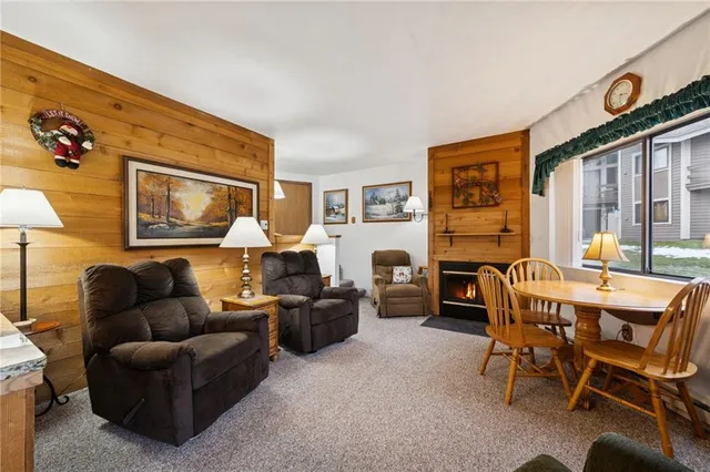 a living room with furniture a fireplace and a large window