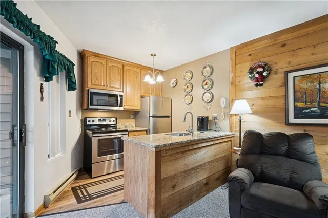 a living room with stainless steel appliances furniture a fireplace and a flat screen tv
