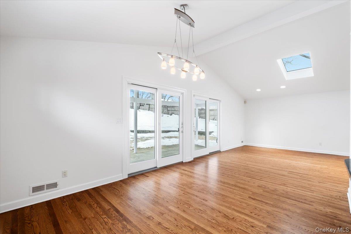 9 Tanglewood Road Scarsdale, NY 10583 - Photo 15 of 33 an empty room with wooden floor chandelier and windows
