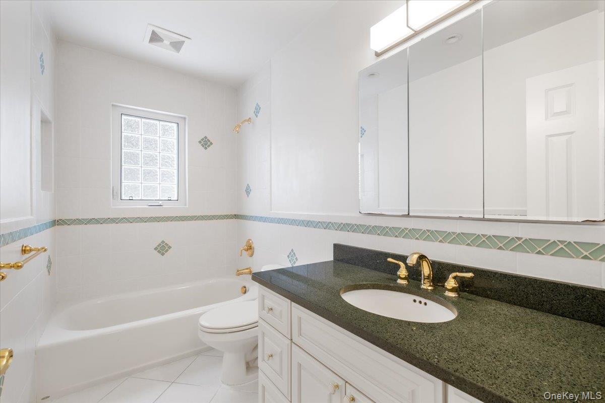 9 Tanglewood Road Scarsdale, NY 10583 - Photo 21 of 33 a bathroom with a granite countertop sink toilet mirror and bathtub