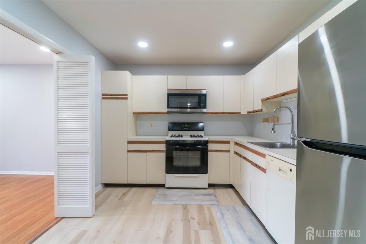 166 Hidden Hollow Court Edison, NJ 08820 - Photo 11 of 36 a kitchen with granite countertop a refrigerator and a stove top oven