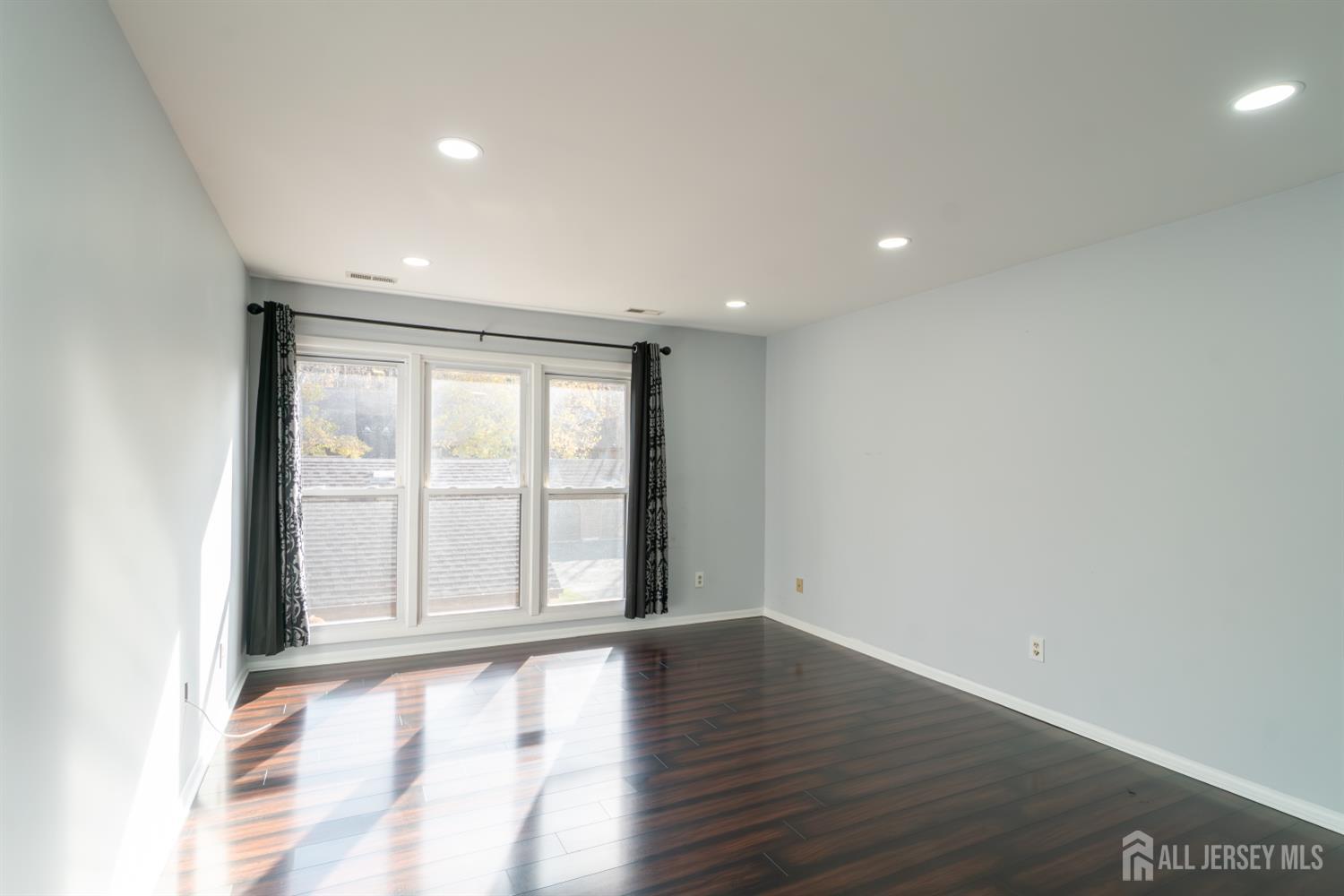 166 Hidden Hollow Court Edison, NJ 08820 - Photo 19 of 36 wooden floor in an empty room with a window