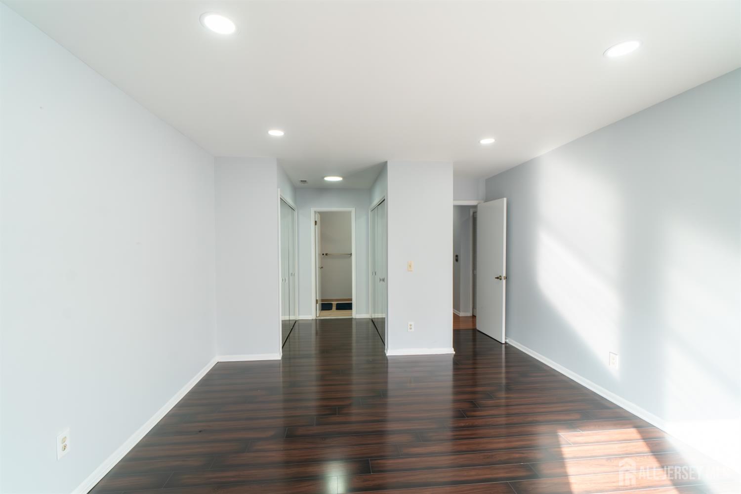 166 Hidden Hollow Court Edison, NJ 08820 - Photo 20 of 36 a view of an empty room with wooden floor