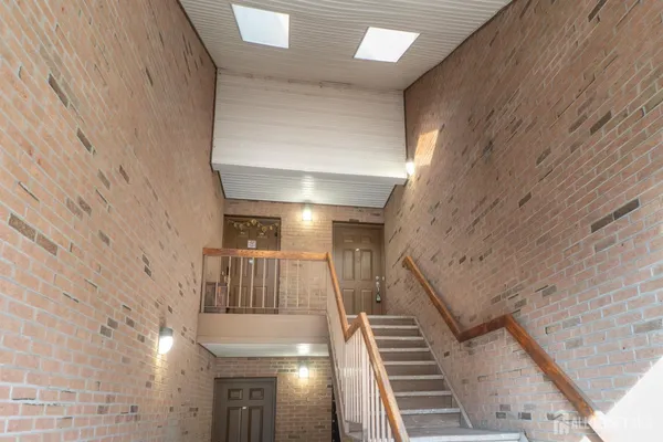 a view of staircase with railing and white walls