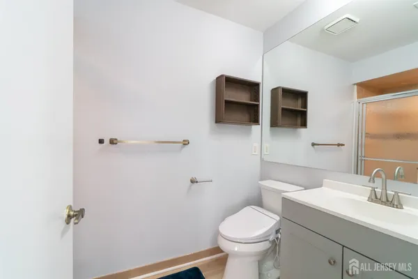 a bathroom with a sink a toilet a mirror and shower