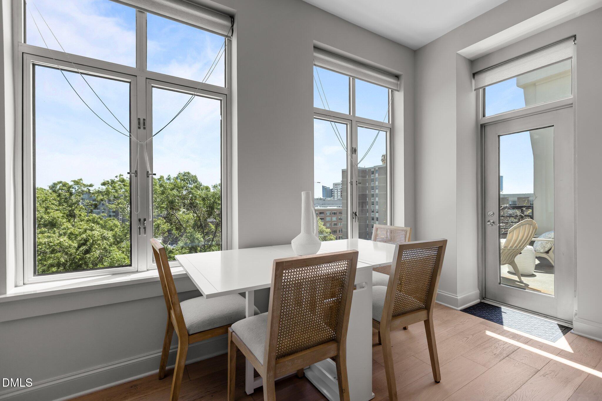 618 North Boylan Avenue, Unit 810 Raleigh, NC 27603 - Photo 12 of 57 a view of a dining room with furniture large windows and wooden floor