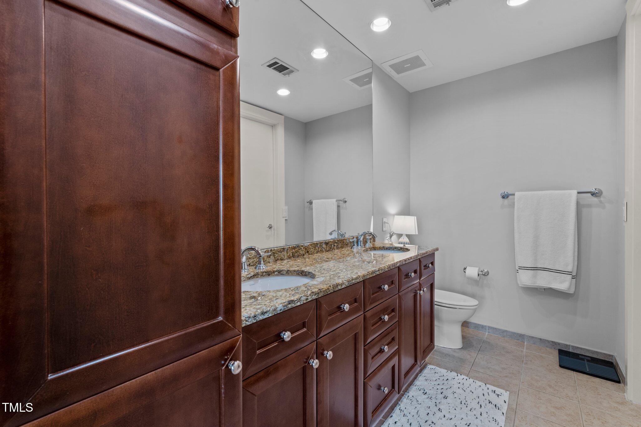 618 North Boylan Avenue, Unit 810 Raleigh, NC 27603 - Photo 30 of 57 a bathroom with a granite countertop sink a toilet and a shower