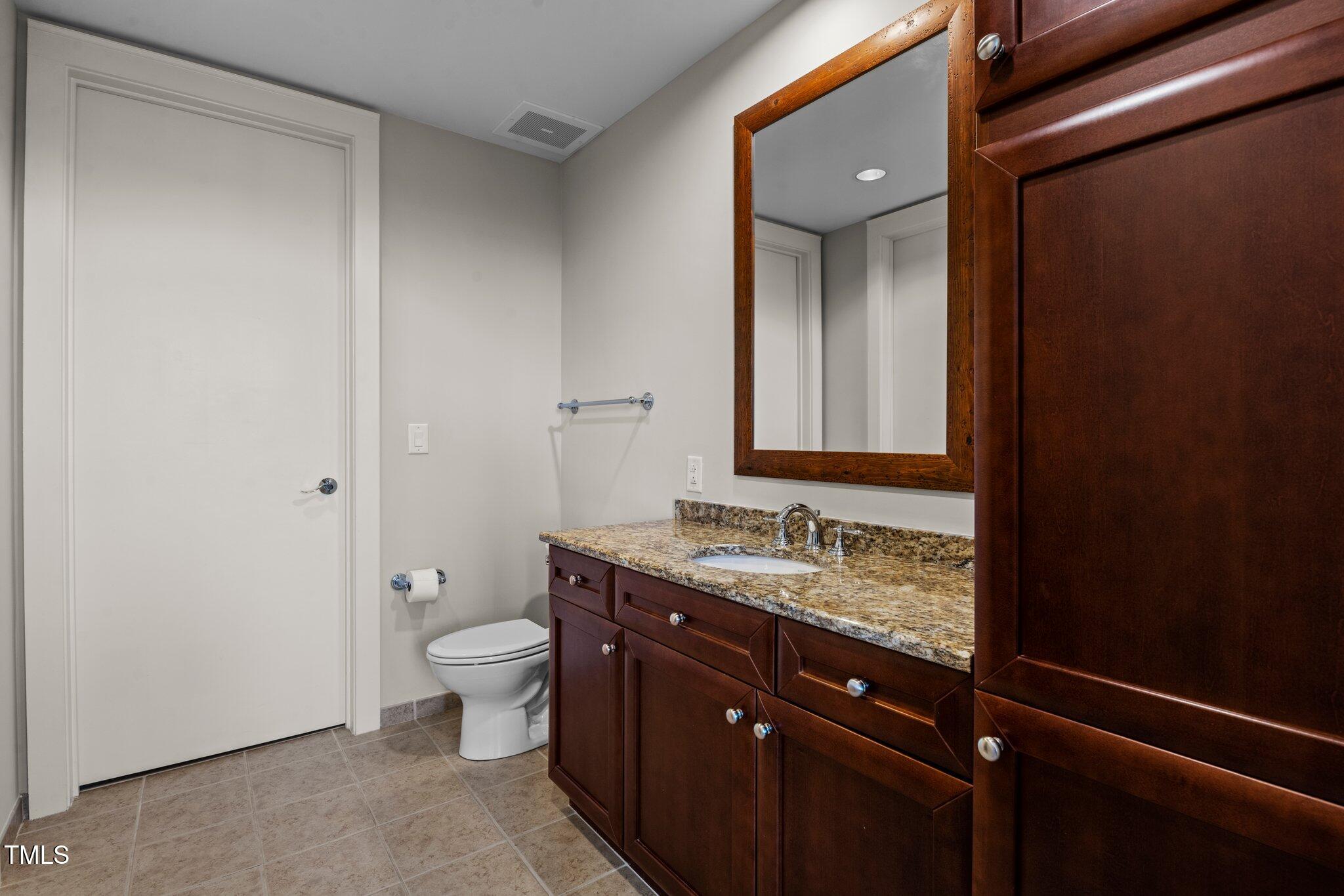618 North Boylan Avenue, Unit 810 Raleigh, NC 27603 - Photo 37 of 57 a bathroom with a granite countertop sink toilet and mirror