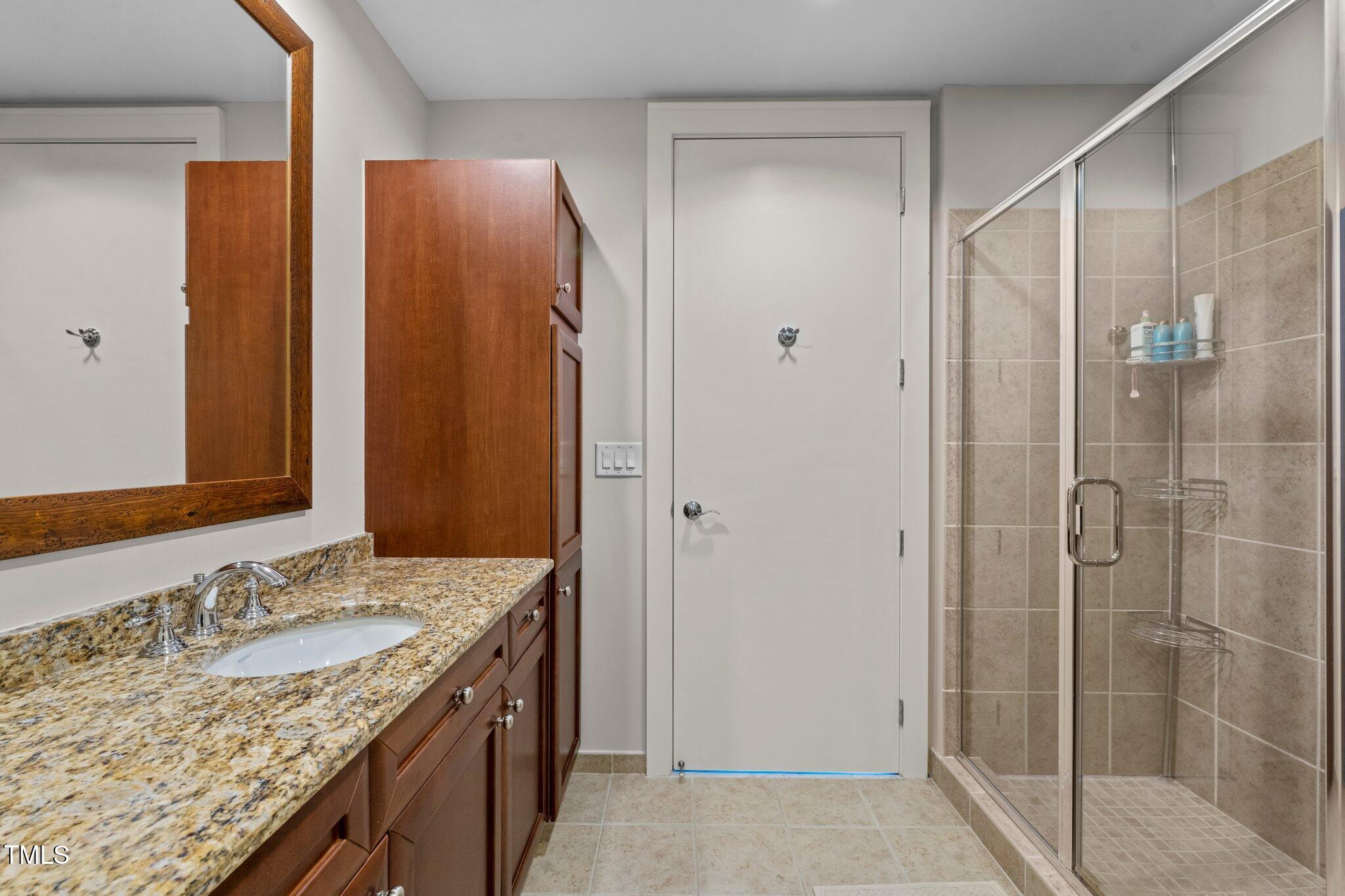 618 North Boylan Avenue, Unit 810 Raleigh, NC 27603 - Photo 38 of 57 a bathroom with a granite countertop sink and shower