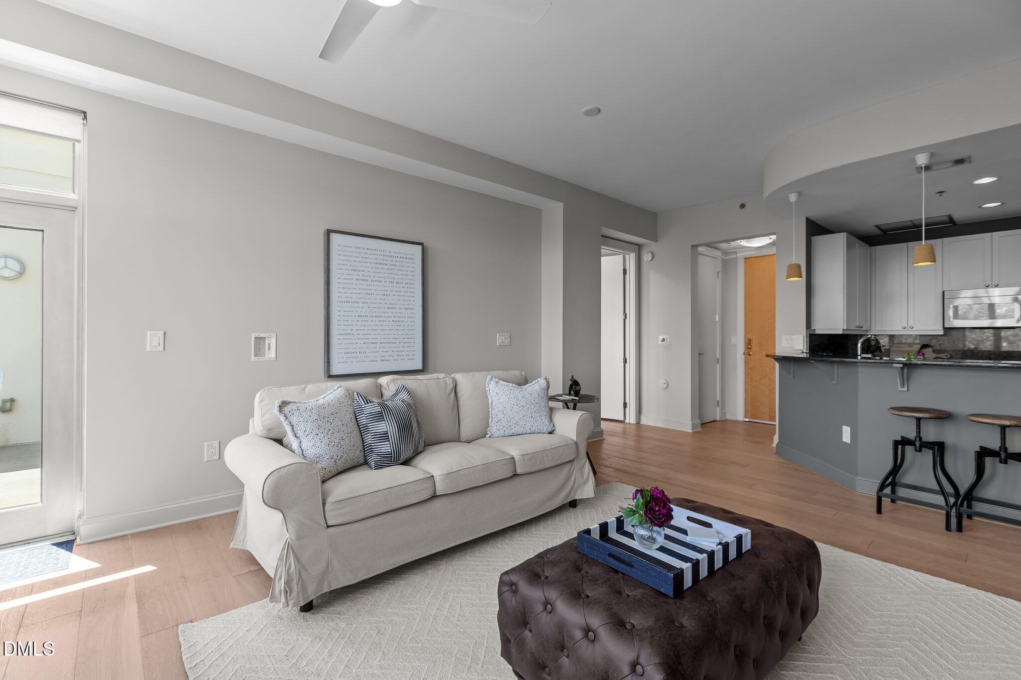 618 North Boylan Avenue, Unit 810 Raleigh, NC 27603 - Photo 9 of 57 a living room with furniture and a dining table with kitchen view