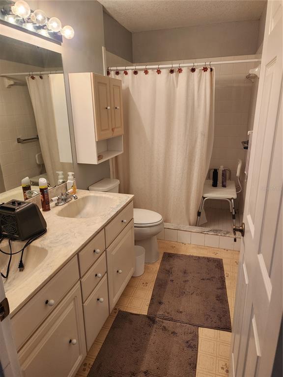 11759 Oswalt Road Clermont, FL 34711 - Photo 19 of 24 a bathroom with a sink a toilet and shower curtain