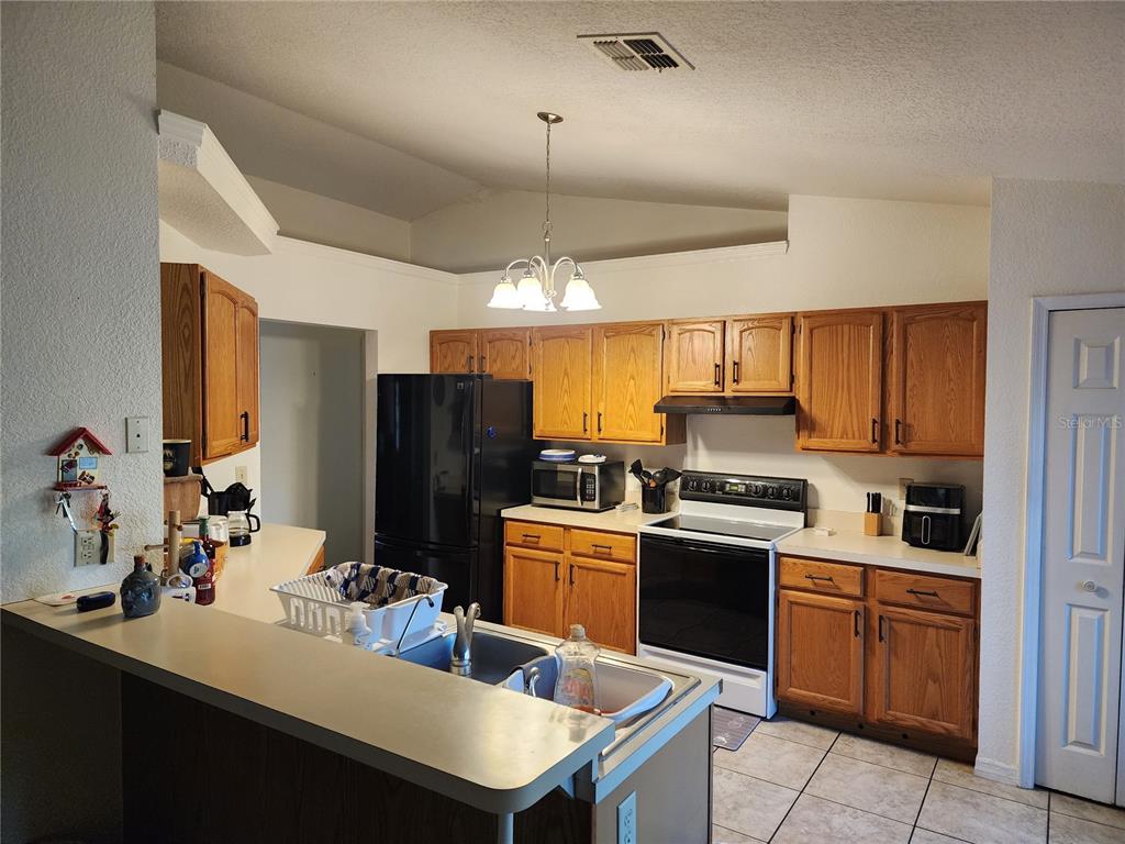 11759 Oswalt Road Clermont, FL 34711 - Photo 3 of 24 a kitchen with a sink stove and refrigerator
