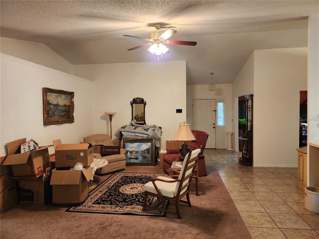 11759 Oswalt Road Clermont, FL 34711 - Photo 4 of 24 a living room with furniture a chandelier and a dining table