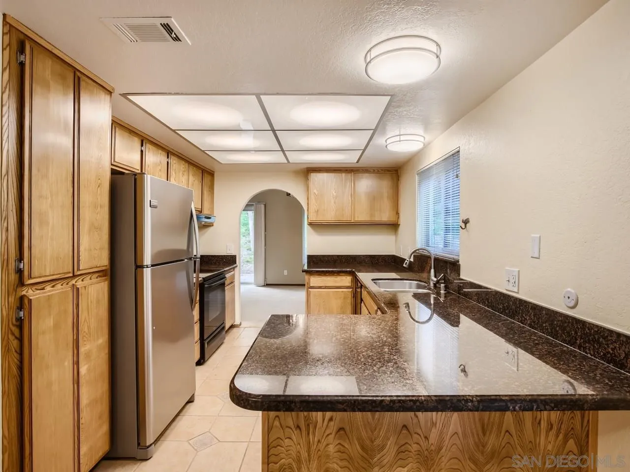 124 Candy Lane Encinitas, CA 92024 - Photo 7 of 27 a kitchen with stainless steel appliances granite countertop a sink a refrigerator and a granite counter tops
