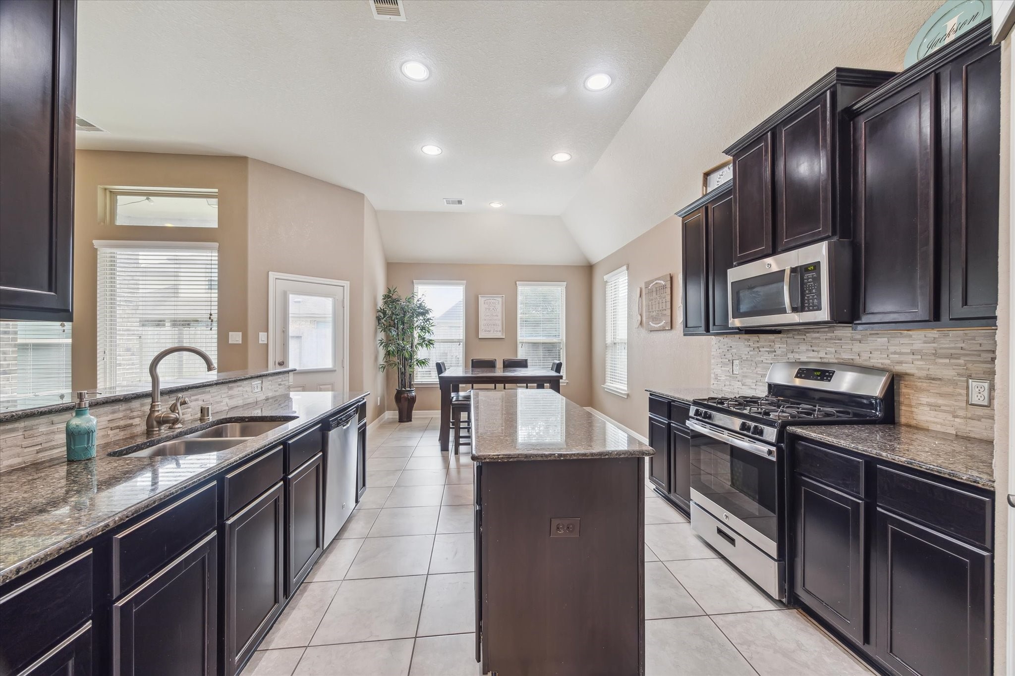 4914 Mountain Maple Trail Rosenberg, TX 77471 - Photo 13 of 24 Another bright view of the kitchen showcasing plentiful natural light and functional layout.