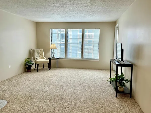 an empty room with furniture and a flat screen tv