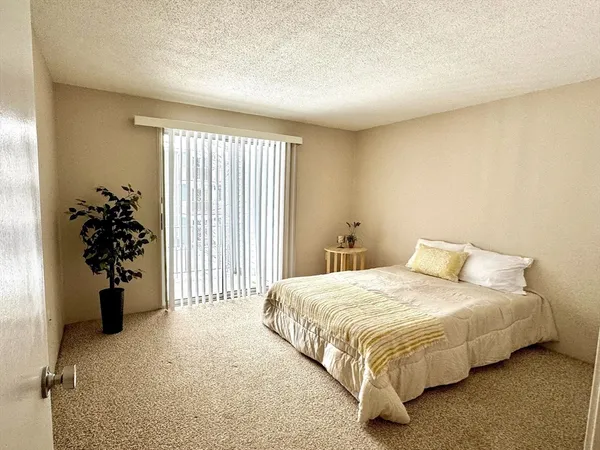 a bedroom with a bed and a large window