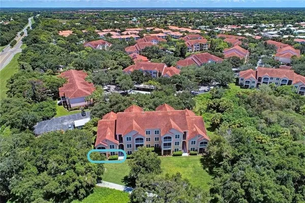 an aerial view of residential houses with outdoor space and trees