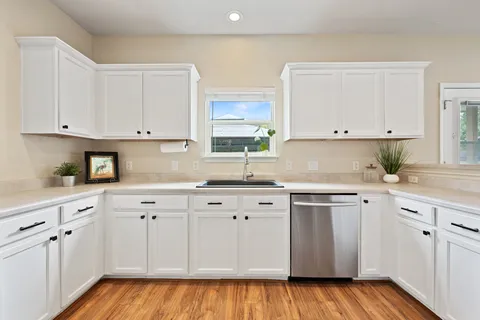 a kitchen with white cabinets and white appliances