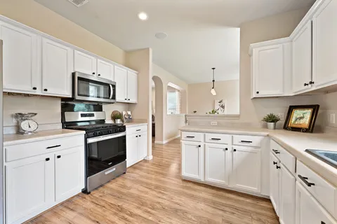 a kitchen with granite countertop a sink cabinets stainless steel appliances and a counter space