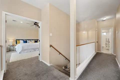 a view of a hallway with a couch and a lamp on table and a mirror
