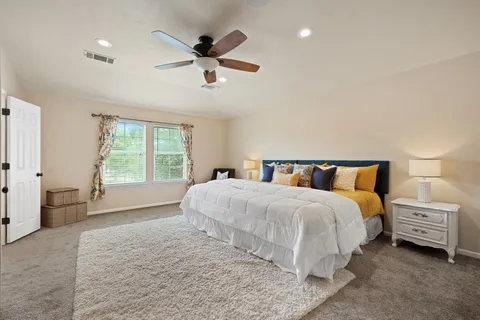 a spacious bedroom with a bed and a large window