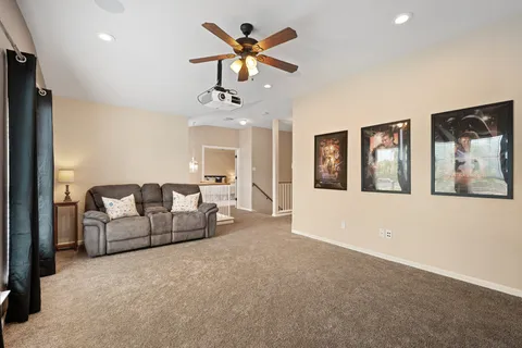 a living room with furniture and ceiling fan