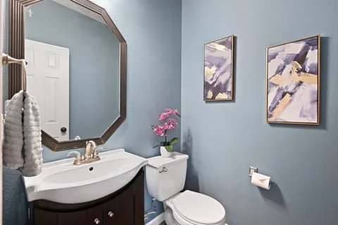 a bathroom with a sink mirror and toilet