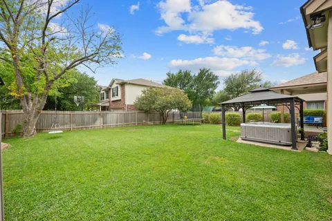 a view of a house with backyard and sitting area