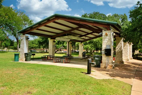 a view of a patio with table and chairs under an umbrella with a swimming pool