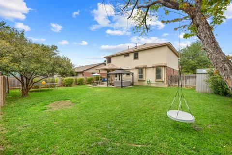 a view of a house with a big yard and a large tree