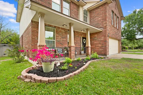a front view of a house with a yard and fountain