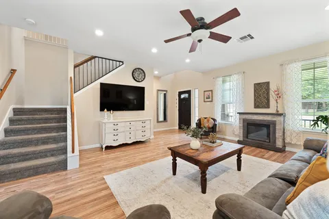 a living room with furniture a fireplace and a flat screen tv