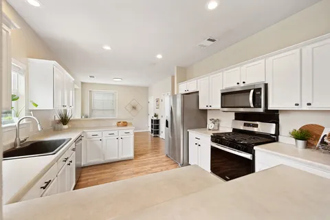 a kitchen with granite countertop a sink stainless steel appliances and cabinets