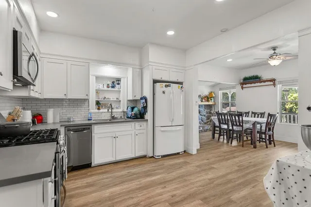 a kitchen that has a lot of cabinets a sink and appliances in it