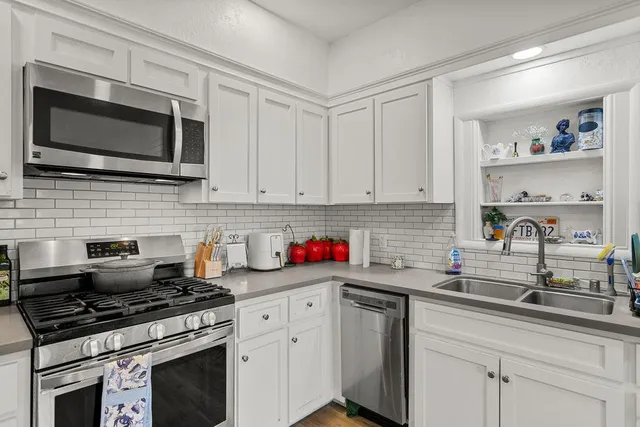 a kitchen with stainless steel appliances a sink dishwasher stove microwave and cabinets