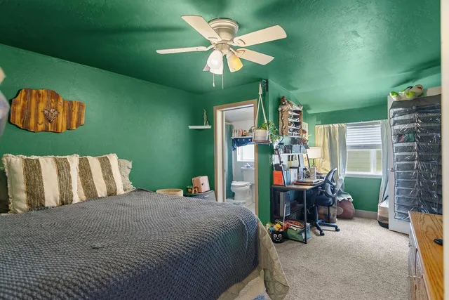 a bedroom with a bed table and chair